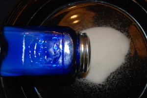 Salt spilled from blue-glass salt shaker.
